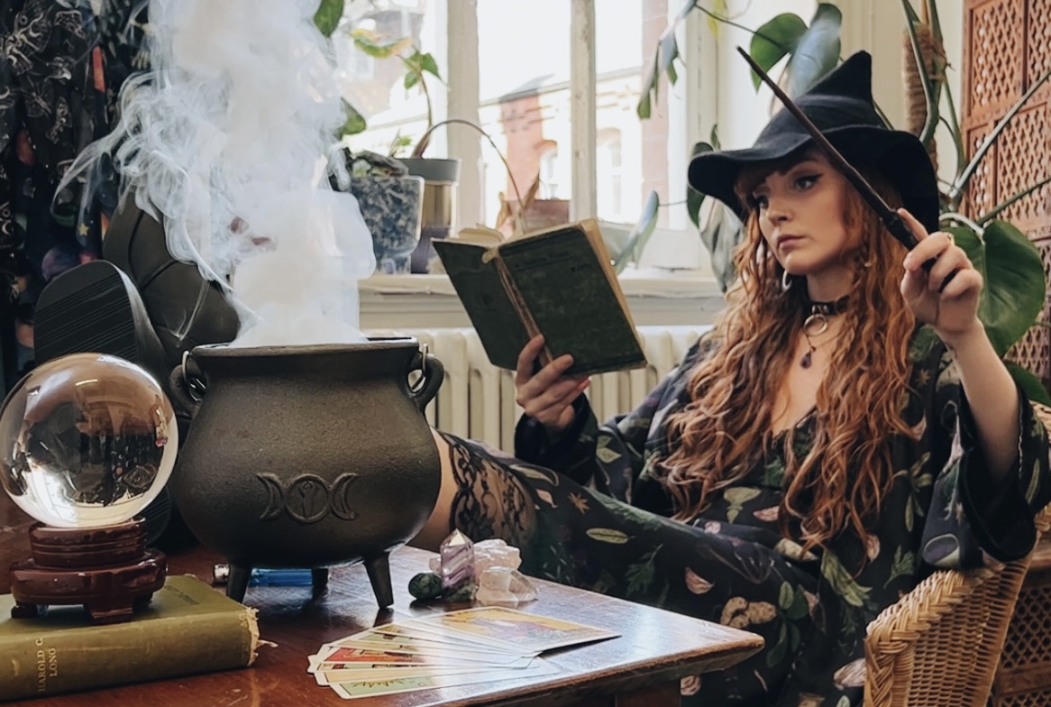 a witch with her smoking cauldron and crystal ball