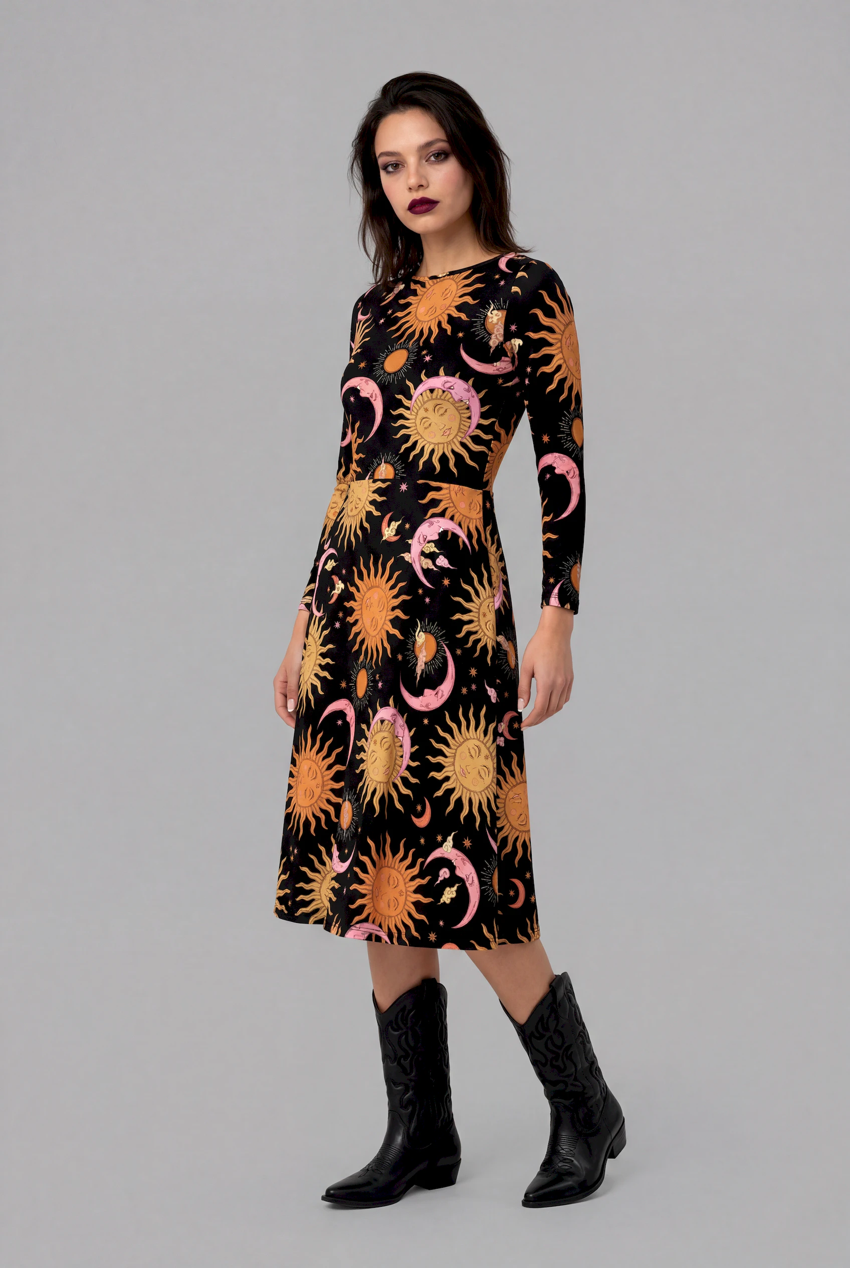 Side angle of Celestial Dreams print long sleeve midi dress with celestial sun and moon design on black fabric