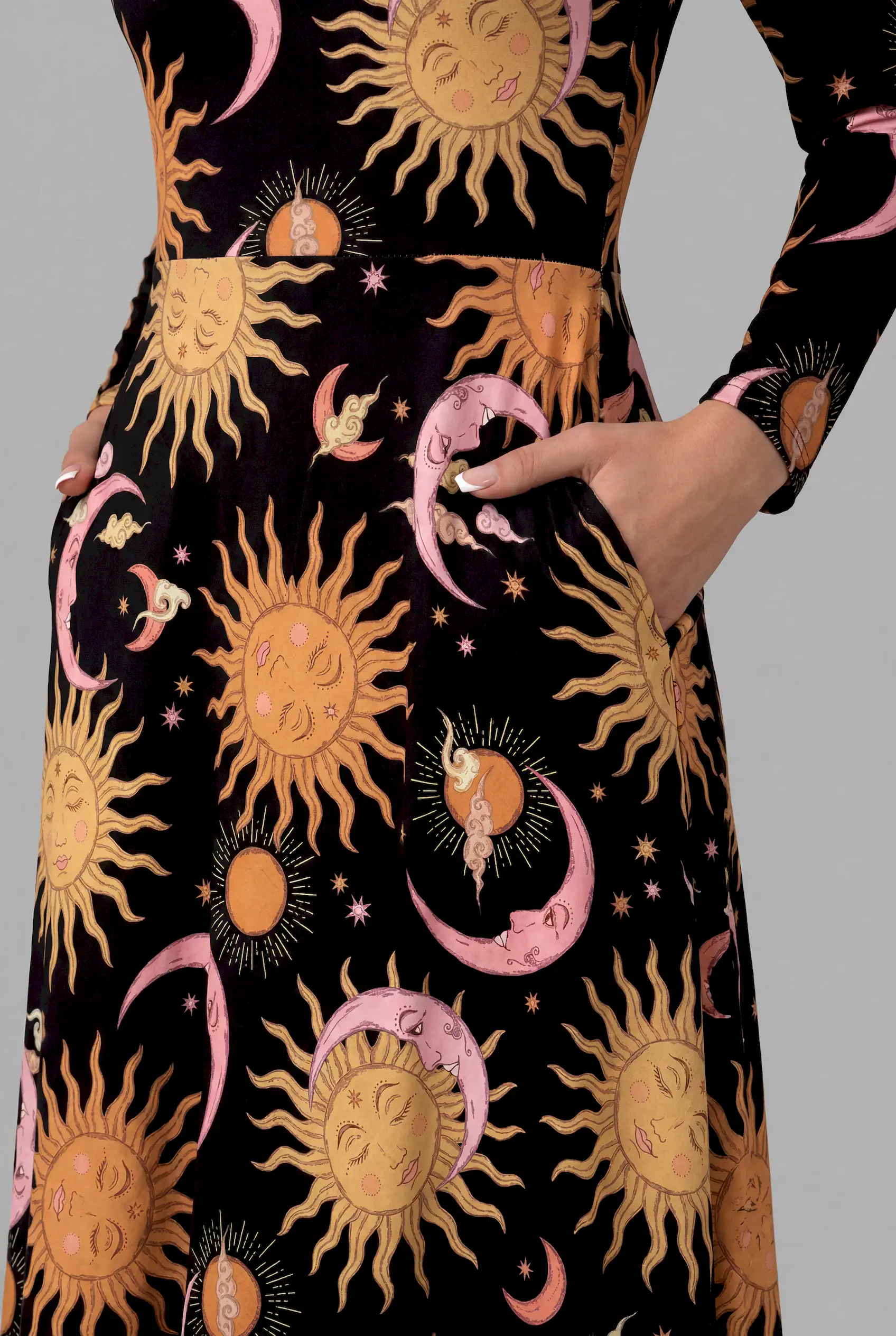 Detailed close-up of Celestial Dreams print long sleeve midi dress with pink crescent moons and golden sun faces
